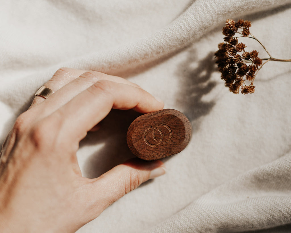 Hand holding a wooden object with a blurred background